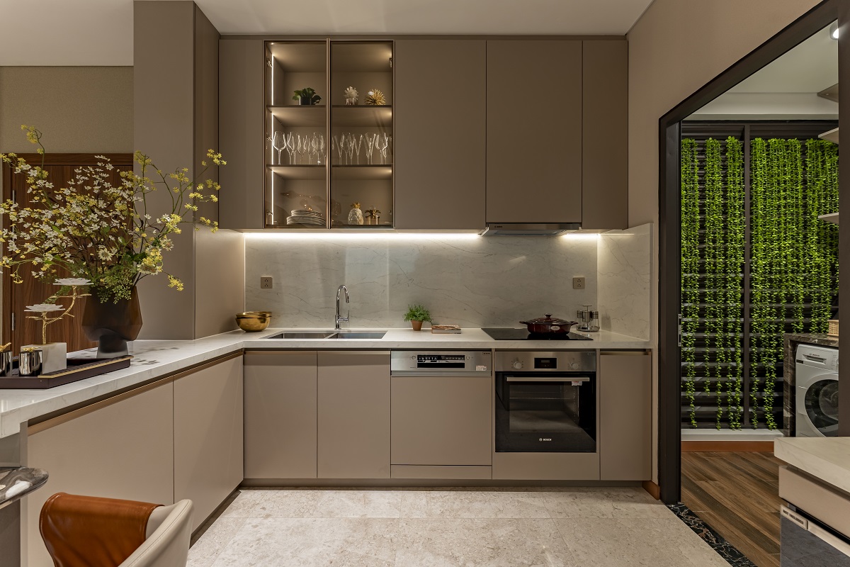 Hệ tủ bếp tr&ecirc;n &ndash; dưới được ho&agrave;n thiện bằng gỗ laminated v&acirc;n da, mang lại cảm gi&aacute;c tinh tế v&agrave; sang trọng, kết hợp c&ugrave;ng hệ đ&egrave;n hắt tạo chiều s&acirc;u thị gi&aacute;c, t&ocirc;n l&ecirc;n vẻ sang trọng cho to&agrave;n bộ kh&ocirc;ng gian.