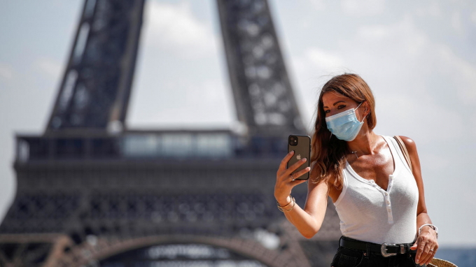 Một du khách đeo khẩu trang chụp ảnh tại tháp Eiffel. Ảnh: France 24. Một du khách đeo khẩu trang chụp ảnh tại tháp Eiffel. Ảnh: France 24.