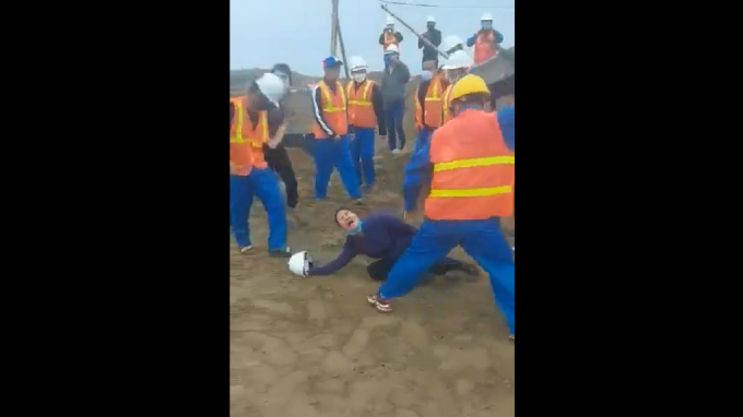 H&igrave;nh ảnh một người phụ nữ bị nh&oacute;m c&ocirc;ng nh&acirc;n d&ugrave;ng d&ugrave;i cui tấn c&ocirc;ng.