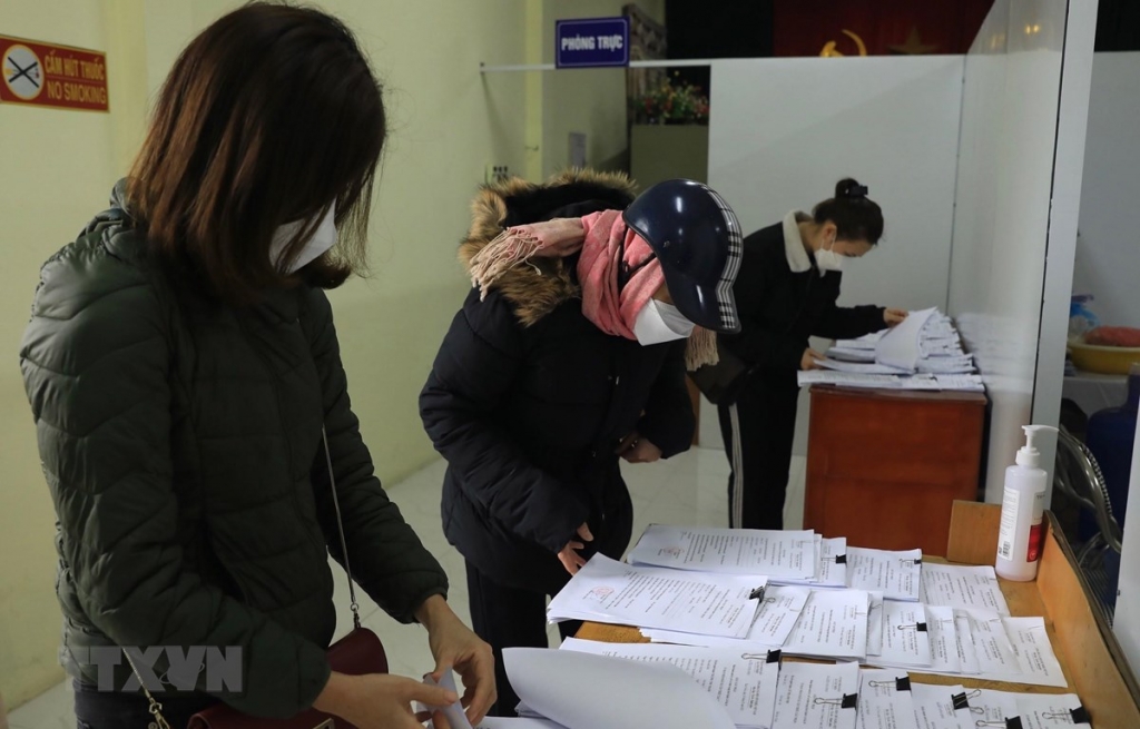 Người d&acirc;n lấy giấy x&aacute;c nhận F0 tại phường. (Ảnh: Ho&agrave;ng Hiếu/TTXVN)