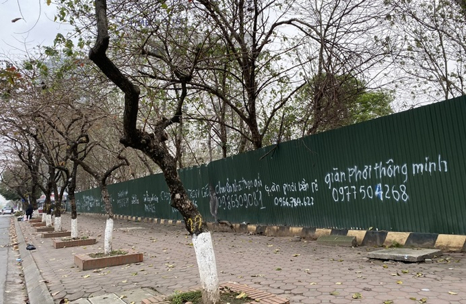 Tại mặt đường ng&atilde; 5 Trần Th&aacute;i T&ocirc;ng, những tấm t&ocirc;n chằng chịt c&aacute;c chữ viết sơn trắng quảng c&aacute;o đủ loại.