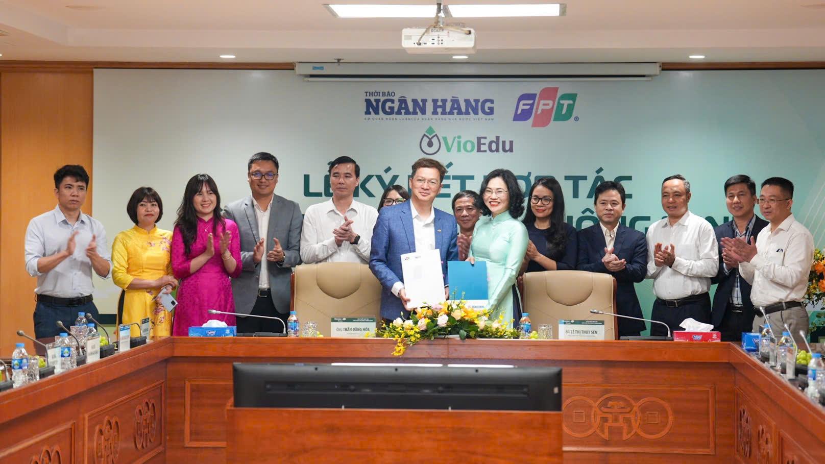 Đại diện Thời b&aacute;o Ng&acirc;n h&agrave;ng v&agrave; đại diện Tập đo&agrave;n FPT trao bi&ecirc;n bản hợp t&aacute;c.