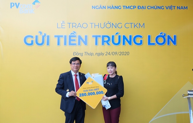 Đại diện PVcomBank trao tặng 280 triệu đồng cho kh&aacute;ch h&agrave;ng may mắn tr&uacute;ng giải Đặc biệt của chương tr&igrave;nh &ldquo;Gửi tiền tr&uacute;ng lớn&rdquo;. Ảnh: Hạnh Hồng &nbsp;