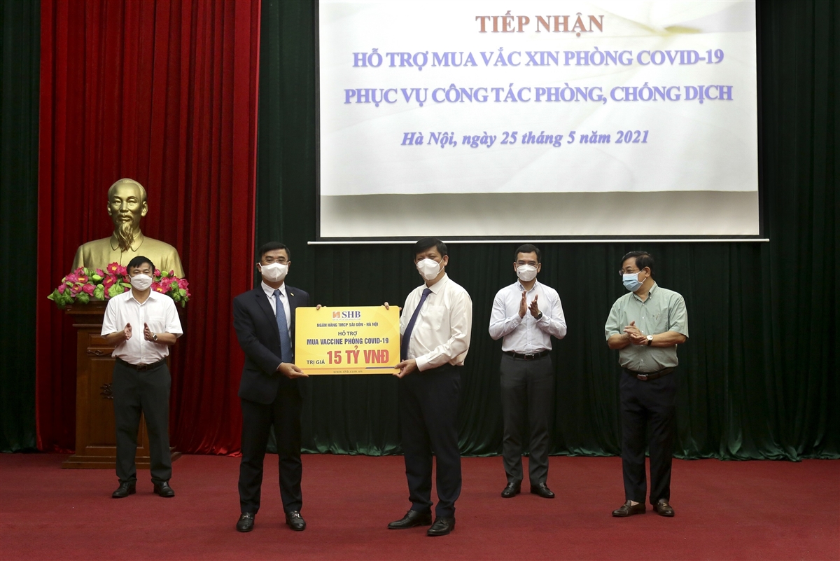 Tổng Gi&aacute;m đốc Nguyễn Văn L&ecirc; - đại diện SHB trao tặng Bộ Y tế 15 tỉ đồng hỗ trợ kinh ph&iacute; mua vaccine ph&ograve;ng COVID-19. Ảnh: SHB