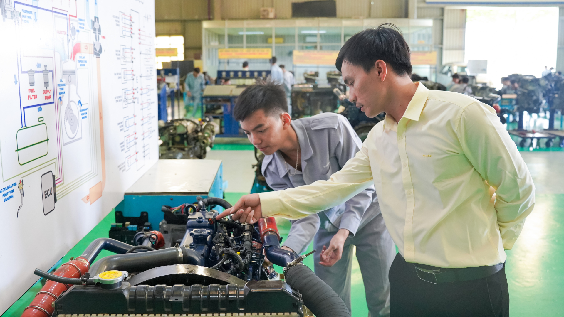 Giảng vi&ecirc;n hướng dẫn sinh vi&ecirc;n thực h&agrave;nh tr&ecirc;n m&ocirc; h&igrave;nh hệ thống điều khiển nhi&ecirc;n liệu diesel