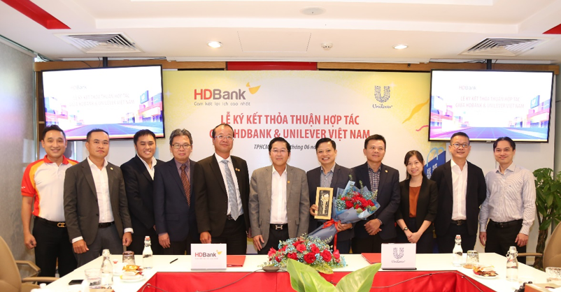 &Ocirc;ng Phạm Quốc Thanh - Tổng Gi&aacute;m đốc HDBank (thứ 6 từ tr&aacute;i sang) trao hoa cho &Ocirc;ng Trương C&ocirc;ng Vĩnh &ndash; Ph&oacute; Chủ tịch Ph&aacute;t triển Kh&aacute;ch h&agrave;ng Unilever Việt Nam (thứ 5 từ phải sang) - Ảnh: HDB &nbsp;
