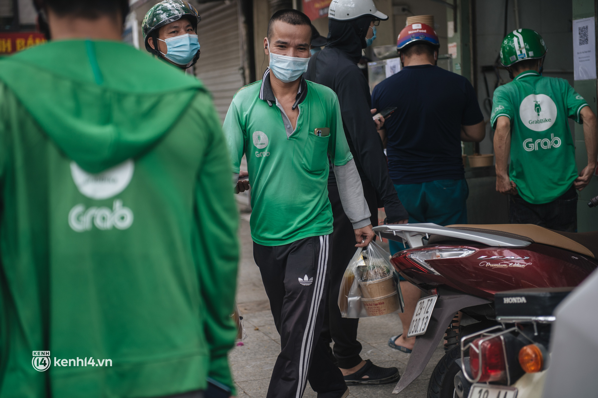 Hà Nội bắt đầu được giao đồ ăn trở lại: Shipper xếp hàng dài chờ mua trong khi khách gọi điện giục liên tục - Ảnh 9