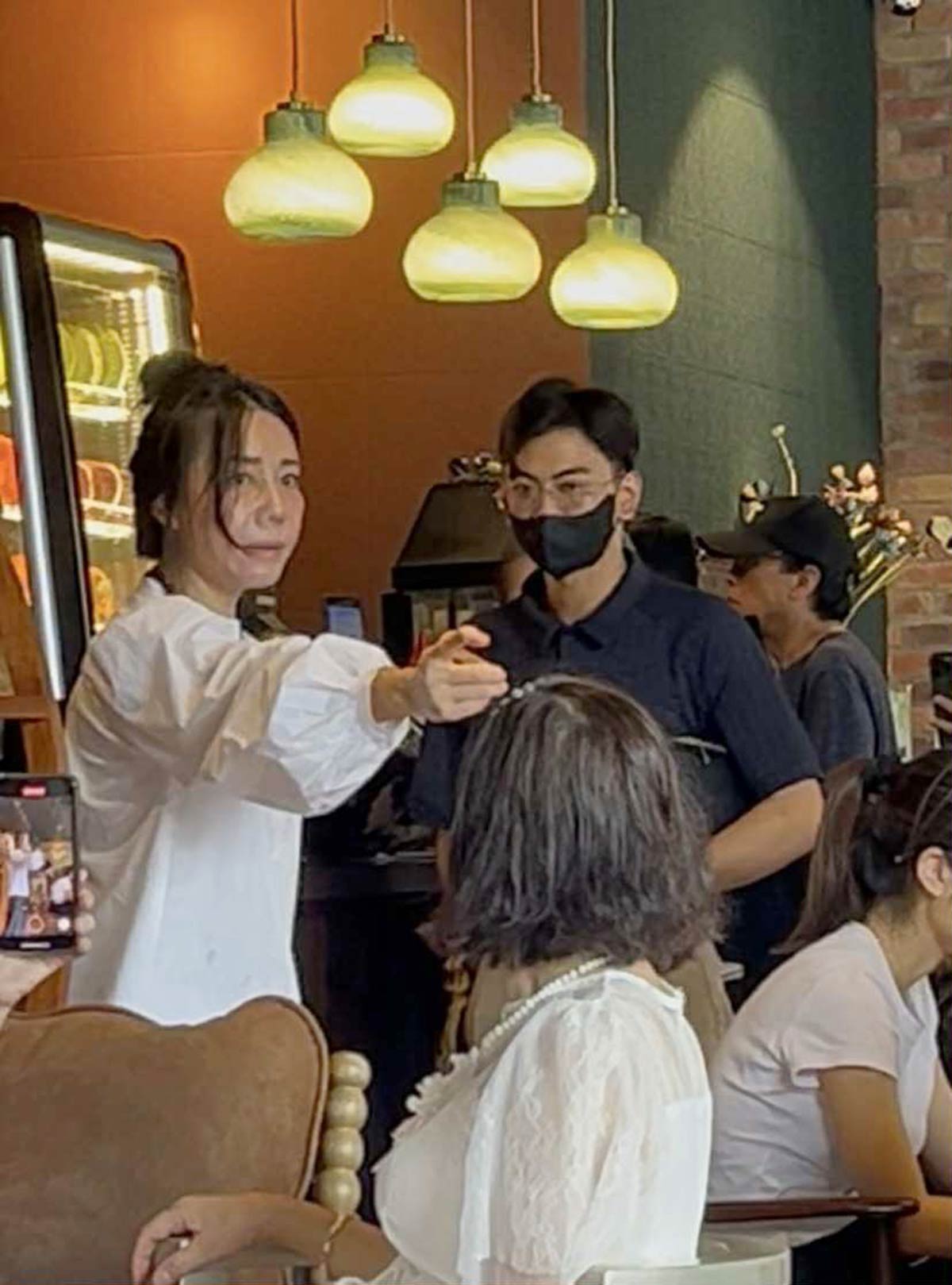 Chủ qu&aacute;n c&agrave; ph&ecirc; (&aacute;o trắng, đang đứng) từ chối lời xin lỗi .v&agrave; mời "tổng t&agrave;i" ra về