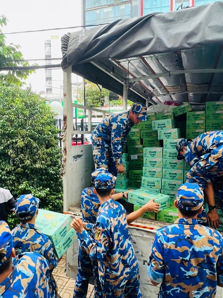 C&aacute;c chiến sĩ Trung t&acirc;m Huấn luyện V&ugrave;ng 4 Hải qu&acirc;n đang chuyền nhau c&aacute;c sản phẩm dinh dưỡng Vinamilk, sẵn s&agrave;ng vận chuyển đến tận tay b&agrave; con v&ugrave;ng lũ - Ảnh: Vi Nam