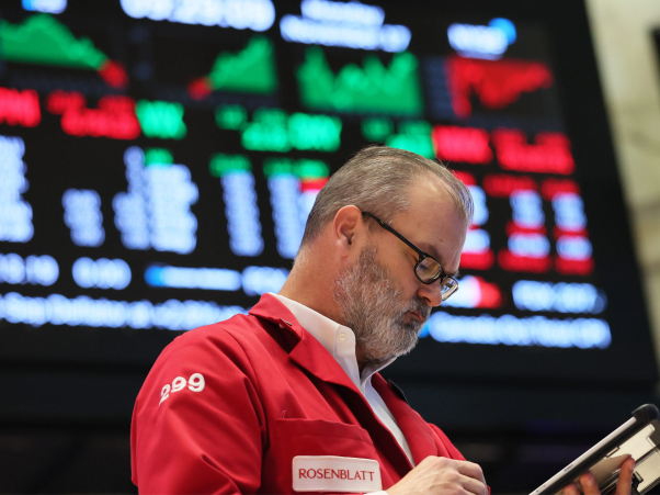 Nh&acirc;n vi&ecirc;n giao dịch tr&ecirc;n s&agrave;n chứng kho&aacute;n theo d&otilde;i dữ liệu thị trường v&agrave; bảng điện tử biến động mạnh. Ảnh: Forturn