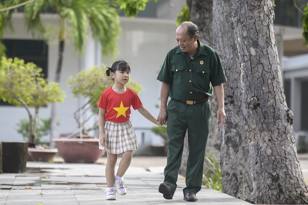 Thượng sĩ Nguyễn Ch&iacute; Tường c&ugrave;ng con một nh&acirc;n vi&ecirc;n Vinamilk tạiTrung t&acirc;m Điều dưỡng Thương binh v&agrave; Người c&oacute; c&ocirc;ng Long Đất (Ảnh: ThanhB&igrave;nh). &nbsp;