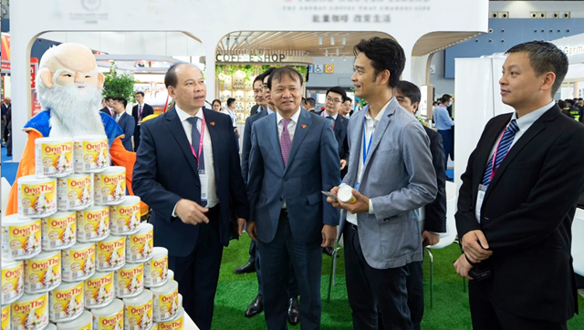Thứ trưởng Bộ C&ocirc;ng thương Đỗ Thắng Hải (đứng giữa) thăm quan gian h&agrave;ng của Vinamilk tại hội chợ quốc tế Quảng Ch&acirc;u.