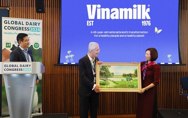 Đại diện Vinamilk trao tặng bức tranh trang trại Green Farm của Vinamilk đến chủ tịch hội nghị sữa to&agrave;n cầu - &ocirc;ng Richard Hall (b&ecirc;n tr&aacute;i)
