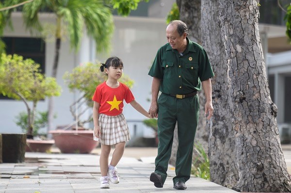 Thượng sĩ Nguyễn Ch&iacute; Tường c&ugrave;ng con một nh&acirc;n vi&ecirc;n Vinamilk tạiTrung t&acirc;m Điều dưỡng Thương binh v&agrave; Người c&oacute; c&ocirc;ng Long Đất (Ảnh: ThanhB&igrave;nh). &nbsp;