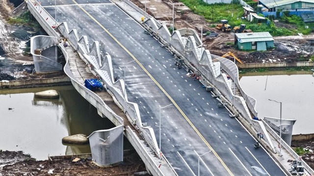 Cây cầu bắc qua rạch Mương Kinh có các lối bộ hành dẫn xuống đôi bên bờ kênh như tạo điểm nhấn cho tuyến đường huyết mạch này - Ảnh: Trần Út   Cây cầu bắc qua rạch Mương Kinh có các lối bộ hành dẫn xuống đôi bên bờ kênh như tạo điểm nhấn cho tuyến đường huyết mạch này - Ảnh: Trần Út  